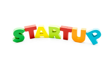 Word STARTUP written with colourful wooden letters, isolated over white with copy space