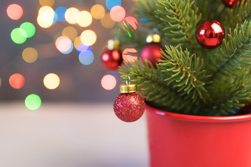 Closeup of red bauble hanging from a decorated Christmas tree. Retro filter effect.
