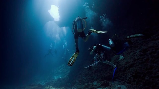 scuba divers inside underwater cavern