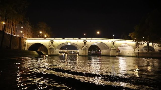 View at bridges from movement boat at night in Paris, France
