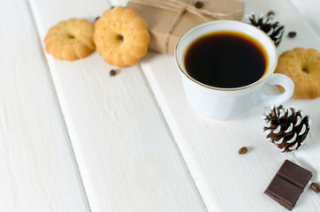 Cup of hot coffee with pastry, new year packs and pine cones