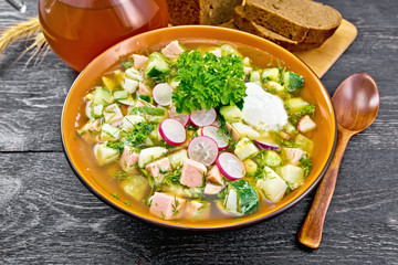 Okroshka in bowl on black wooden board