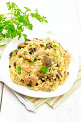 Risotto with mushrooms and chicken on wooden board © kostrez