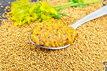 Sauce mustard Dijon in spoon with flower on board