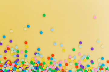 Colorful confetti on yellow background. © cegli