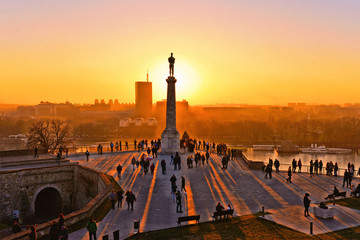 Sunset light on Danube river, statue and silhouettes of people in fortress Kalemegdan in Belgrade Serbia