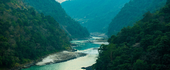 Spectacular view of the sacred Ganges river flowing through the green mountains of Rishikesh,...