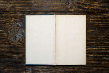 Old open book on wooden background.