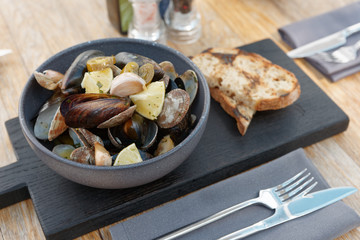 Boiled shellfish in deep clay plate