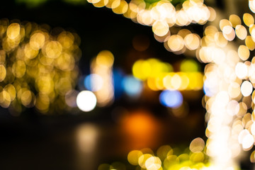 Beautiful bokeh of colorful Christmas lights in a city (Blurry background of illumination and decoration of trees in holiday night)