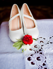 Sweet shoes with a red rose stand on the windowsill