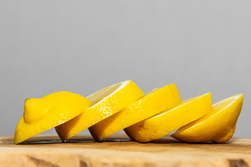 Lemon slices spread out on wood.