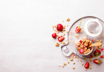 Granola Cereal bar with Strawberries on the Gray Background in a glass jar. Muesli Breakfast. Healthy Food sweet dessert snack. Diet Nutrition Concept. Top View. Vegetarian food.Flat Lay.Copy space