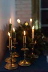 Golden candlesticks with burning candles. New Year's interior decoration.