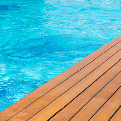 Poolside at resort with wooden decking.