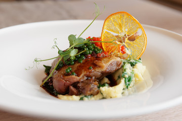 Fried duck leg with molecular caviar, close-up
