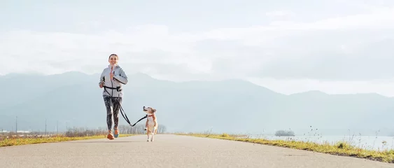 Printed kitchen splashbacks Jogging Bright sunny Morning Canicross exercises. Female runs with his beagle dog and happy smiling.