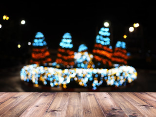 Wood table top over blurry background of Christmas tree lighting