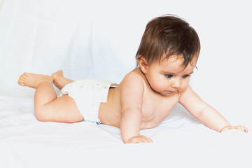 focused beautiful baby in a diaper on white background
