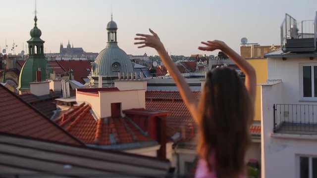 girl waving her arms against the background of the city