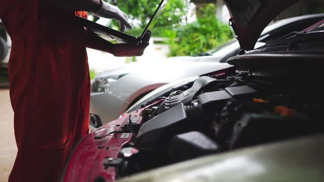 professional mechanic in uniform repairing car in workshop footage