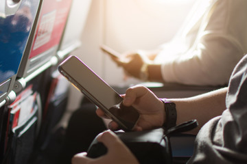 silhouette of people use smartphone on plane. subject is blurred.
