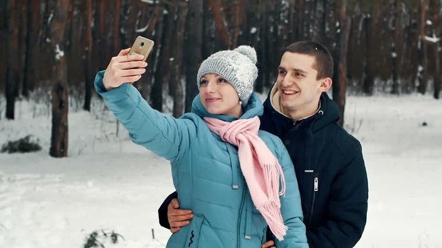 man and woman selfie in winter in the forest