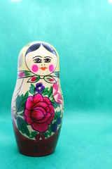 Russian doll against green background with copy space