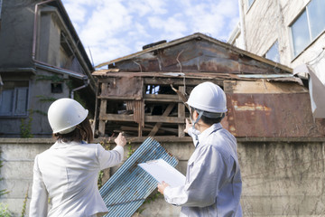 宅地造成前　建物取り壊し工事・打ち合わせをする営業マン　指差し