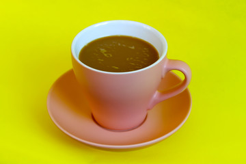 Cocoa drink in pink mug on yelow background