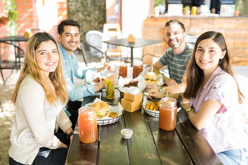 Delighted Men And Women At Outdoor Restaurant