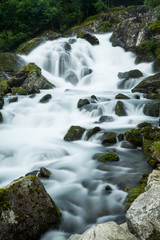 Langzeitbelichtung eines Gerbirgsflusses in Norwegen mit Felsen im Bachlauf, Norwegen