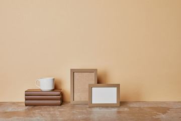  books, photo frames and cup  of coffee on beige background