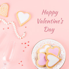 Happy Valentine's day greeting card with cookies, wine glasses on pink background.