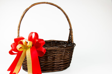 Fototapeta na wymiar empty wicker Basket with red ribbon bow on white background
