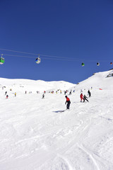 Fototapeta na wymiar Ascenso de montaña y esquiadores que patinan desde una montaña nevada.