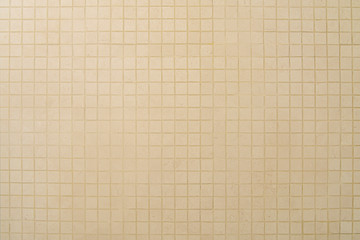 Old beige mosaic wall background texture