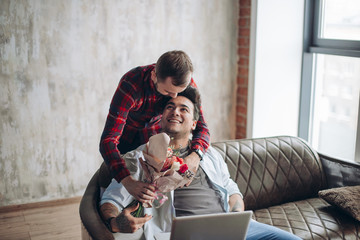 Beautiful romantic homo man presenting flowers to his beloved partner, celebrating birthday in...