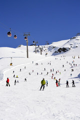 Mountain lift and skiers skating from a snowy mountain