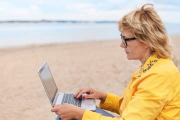 Woman on a beach with her laptop