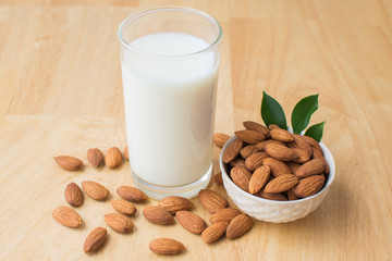 almond and milk on wooden table. soft focus.
