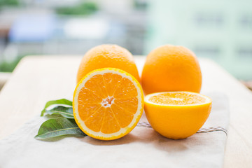 orange and orange juice with leaf on wooden table at sunny day. soft focus.