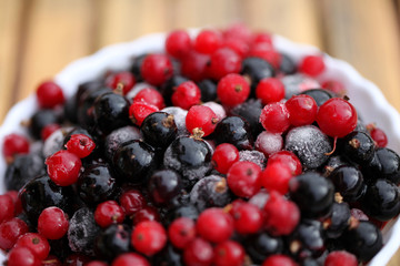 Frozen mixed berries as background. Currant mulberry texture pattern. Diet vegetarian food in winter.