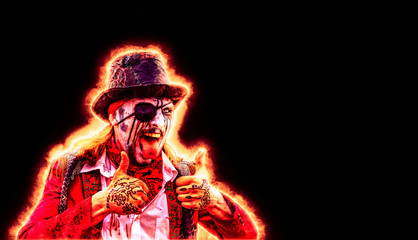 crazy pirate with an eye patch and fire around the silhouette shows the tongue and two hands thumb up. black background, place for copyspace