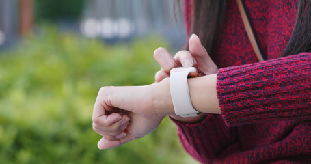 Woman use of smart watch in the park