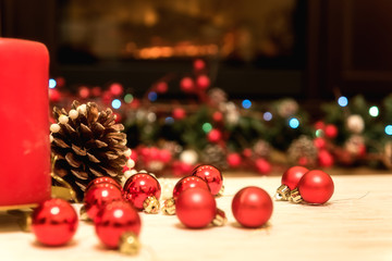 Christmas and New Year background with holiday decoration - candle, cone and red balls with lights and festive bokeh