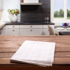 Kitchen towel on empty wooden table. Napkin close up top view mock up for design. Kitchen rustic background.