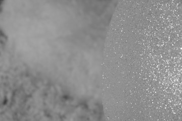 Sparkling silver big ball is in winter snow outside. Concept: festive abstraction or season of winter twilight.