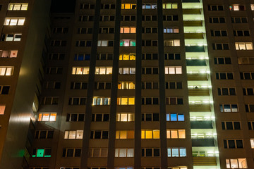 Fototapeta na wymiar high rise facade at night, High-rise facade at night, DDR Plattenbau, glowing windows
