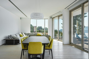Interior of light spacious living room with large panoramic windows in a luxury villa